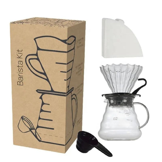 Barista kit with coffee maker, filter, and scoop next to its packaging on a white background
