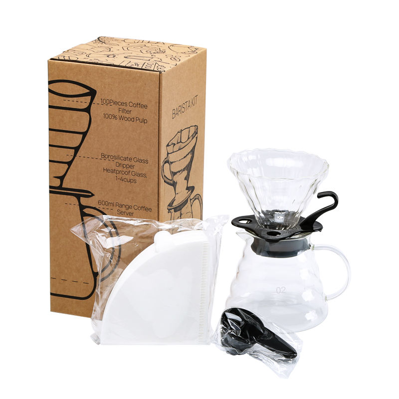Coffee brewing set with glass dripper, filter, and packaging on a white background